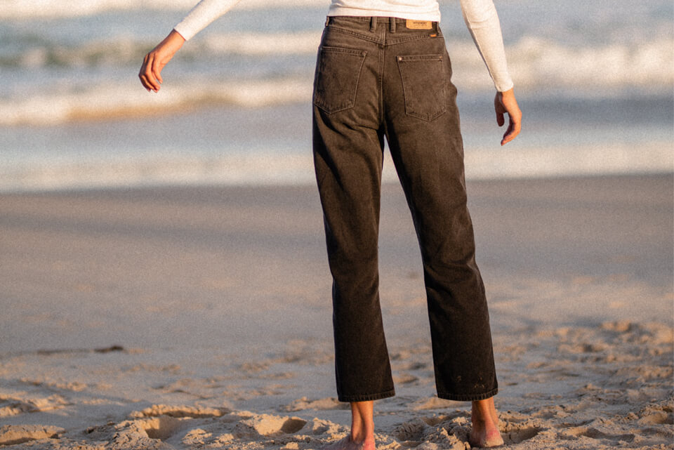 Back of women wearing black wrangler jeans with arms twirling