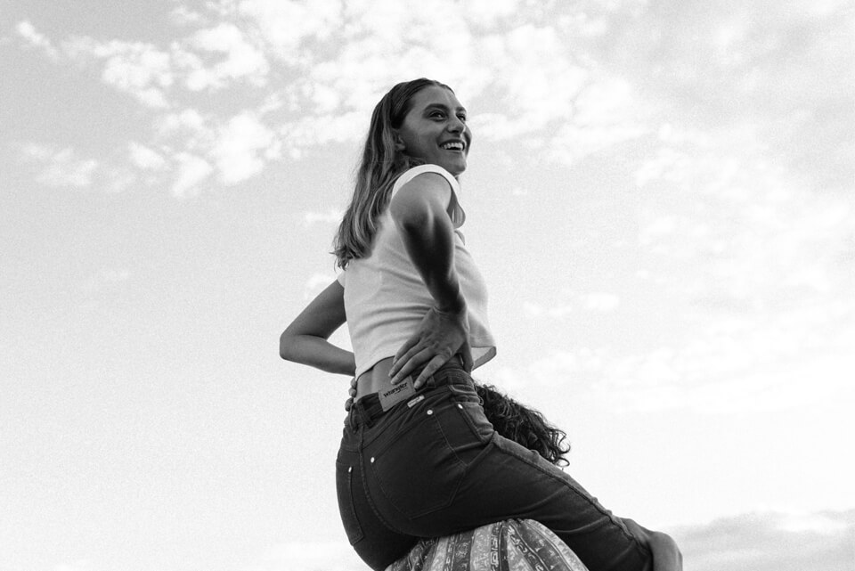 Women smiling on top of mans shoulders in denim